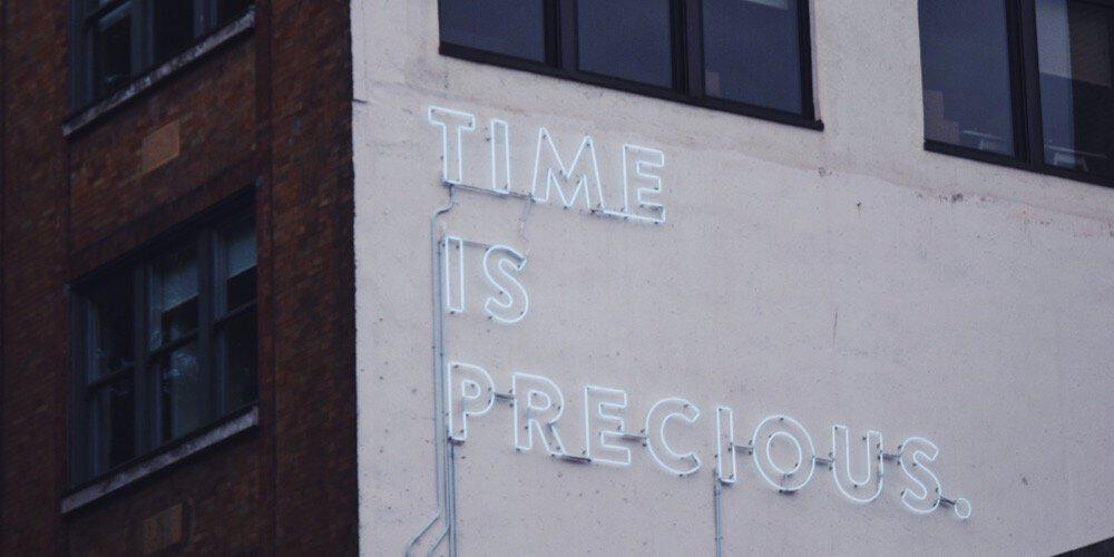 "Time is precious" sign on a building's wall