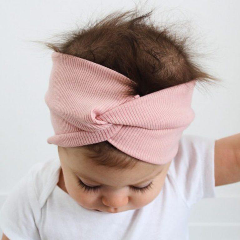 Screenshot of a baby wearing a pink knotted headband 