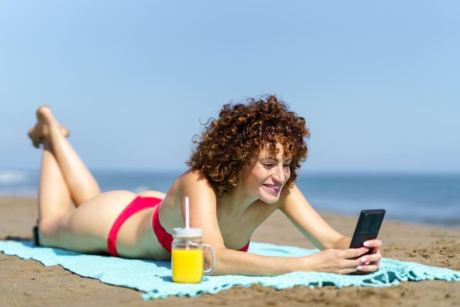 photo woman doing ecommerce on the beach